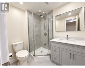 A bathroom with a toilet, sink, and shower.