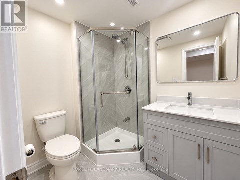 A bathroom with a toilet, sink, and shower.
