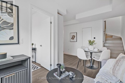 A living room with a dining table and chairs.