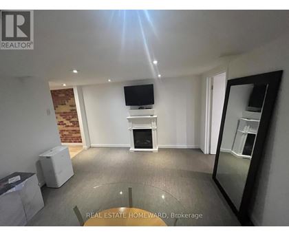 A living room with a flat screen TV mounted on the wall and a fireplace in the center.