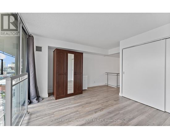A room with a white wall and a wooden floor.