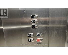 Elevator buttons with a REALTOR sign on the left.