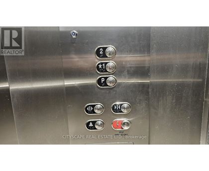 Elevator buttons with a REALTOR sign on the left.