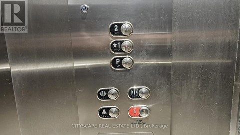Elevator buttons with a REALTOR sign on the left.