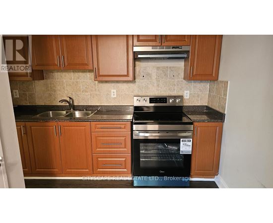 A kitchen with wooden cabinets and a black oven.