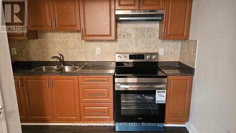 A kitchen with wooden cabinets and a black oven.