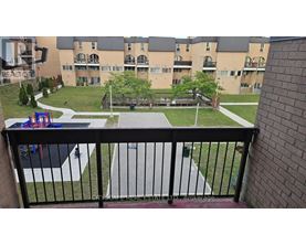 A balcony view of a playground and apartment complex.