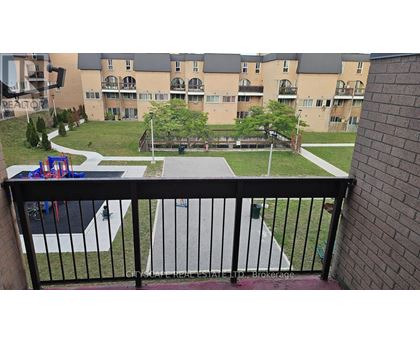 A balcony view of a playground and apartment complex.