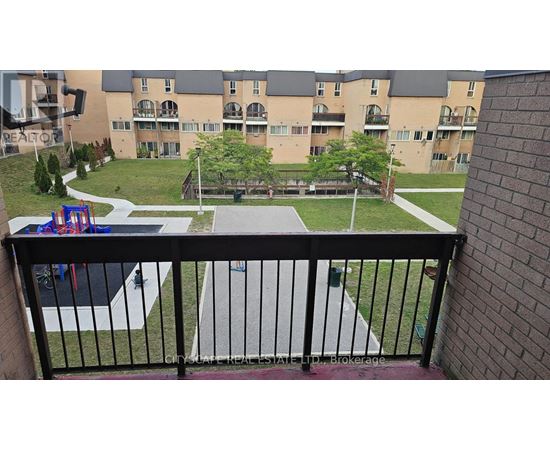 A balcony view of a playground and apartment complex.