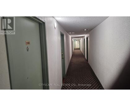 A long hallway with doors on either side and a sign on the wall.