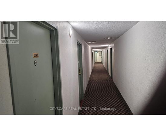 A long hallway with doors on either side and a sign on the wall.