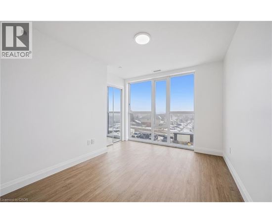 A spacious room with a view of the city through large windows.