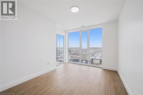 A spacious room with a view of the city through large windows.