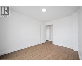 A spacious room with wooden flooring and white walls.