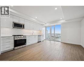 A well-lit, spacious kitchen with white cabinets and a stainless steel oven.