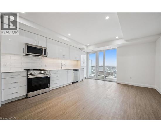 A well-lit, spacious kitchen with white cabinets and a stainless steel oven.