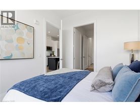 A bedroom with a large bed and a painting on the wall.