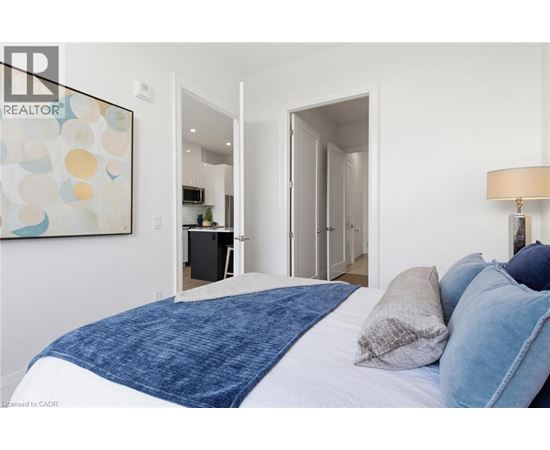 A bedroom with a large bed and a painting on the wall.