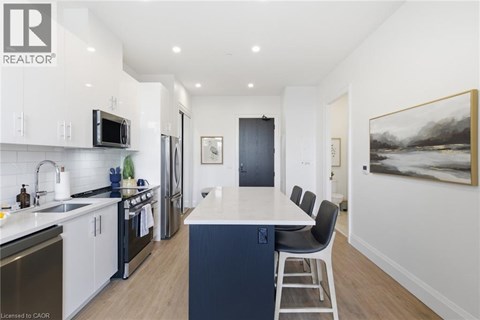 A modern kitchen with a large island and stainless steel appliances.