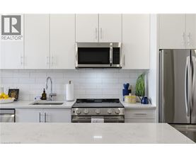 A modern kitchen with white cabinets and stainless steel appliances.