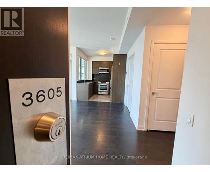 A hallway with a door on the right and a sign on the wall that says REALTOR.