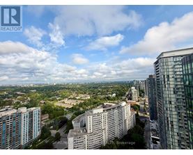 A cityscape with buildings and a cloudy sky.