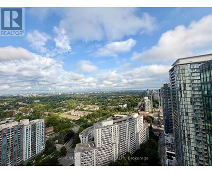 A cityscape with buildings and a cloudy sky.