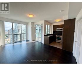 A spacious living room with a view of the cityscape outside the large windows.