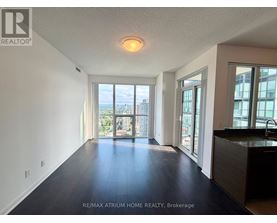 A spacious room with a view of the cityscape through the windows.
