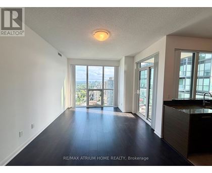 A spacious room with a view of the cityscape through the windows.