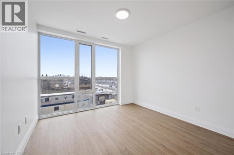 A large empty room with a view of the city through the windows.