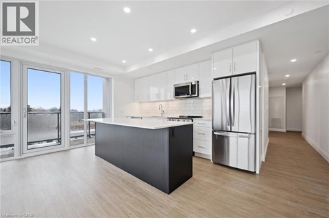 A modern kitchen with a large island and stainless steel appliances.