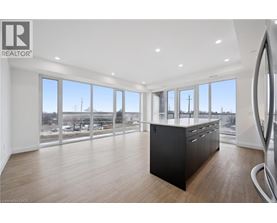 A spacious room with a large window overlooking a parking lot.