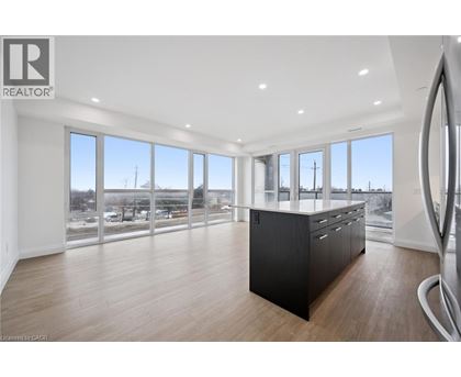A spacious room with a large window overlooking a parking lot.