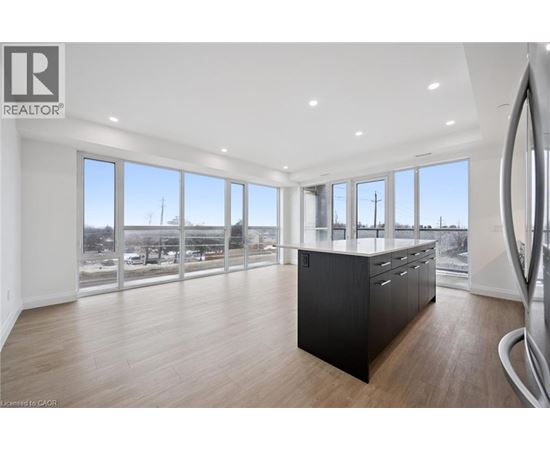 A spacious room with a large window overlooking a parking lot.