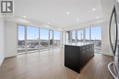 A spacious room with a large window overlooking a parking lot.
