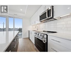 A modern kitchen with white cabinets and a black stove top oven.