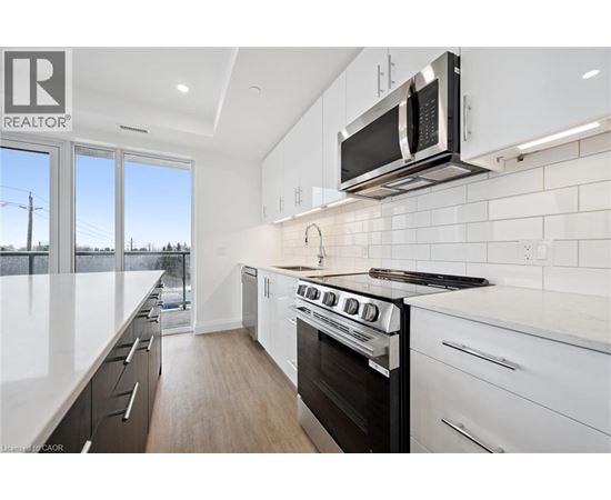 A modern kitchen with white cabinets and a black stove top oven.