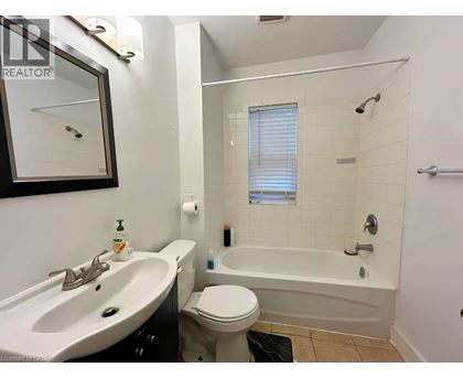 A white toilet sits next to a white bathtub in a bathroom.