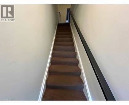 A staircase with a black railing and brown steps.