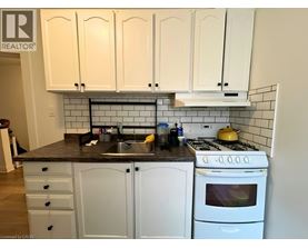 A kitchen with white cabinets and a black countertop.
