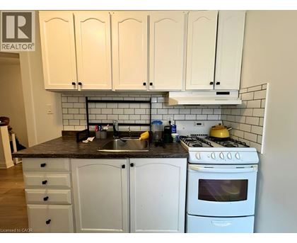 A kitchen with white cabinets and a black countertop.