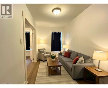 A well-lit living room with a grey couch and wooden coffee table.