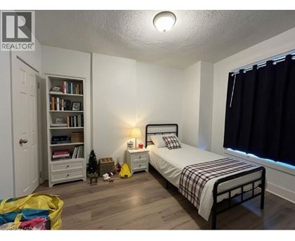 A bedroom with a bed, nightstand, and bookshelf.