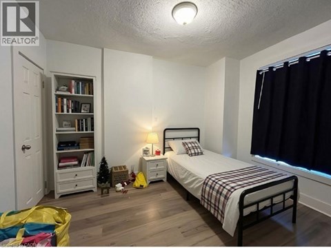 A bedroom with a bed, nightstand, and bookshelf.