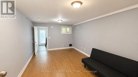 A living room with a black couch and a doorway leading to another room.