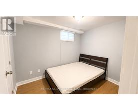 A bedroom with a bed, wooden headboard, and a window.