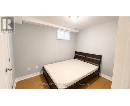 A bedroom with a bed, wooden headboard, and a window.
