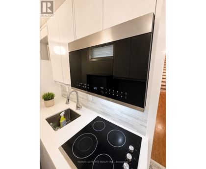 A modern kitchen with a black stove top oven.