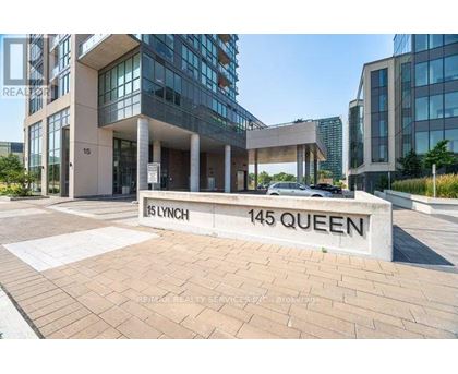 The image shows a building entrance with a sign that reads "15 LYNCH 145 QUEEN".